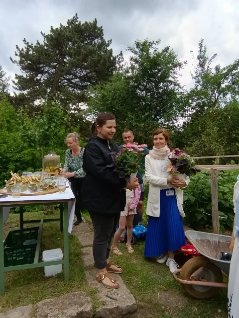 Blumen und Gäste bei der Einweihung des mobilen Spielepunkts in Holzdorf