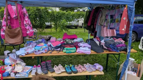 Flohmarktstand mit Kleidung und Schuhen beim Dorfflohmarkt Legefeld 2026