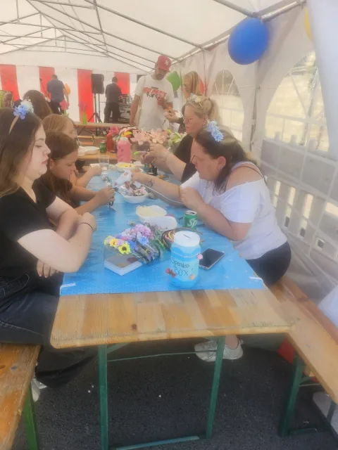 Kinder und Jugendclub-Mitglieder basteln Maienkränze im Festzelt