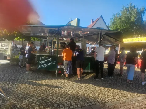 Besucherinnen und Besucher am Getränkewagen beim Maientanz in Legefeld