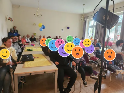 Familien beim Weltkindertag im Bürger- und Vereinshaus; die Kinderköpfe sind mit Smileys verdeckt