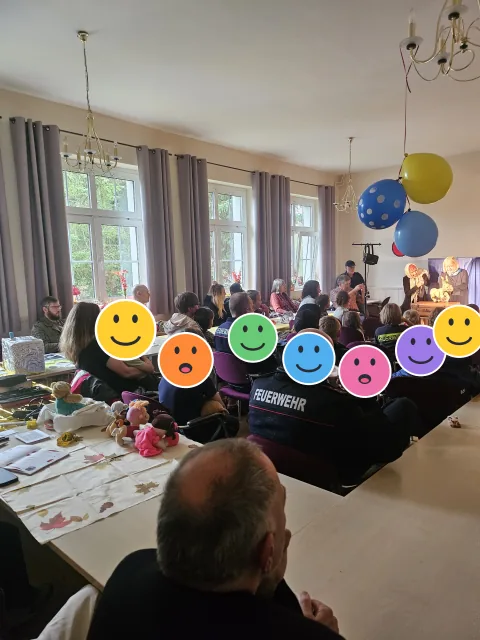 Publikum beim Puppentheater zum Weltkindertag; die Kinderköpfe sind mit Smileys verdeckt