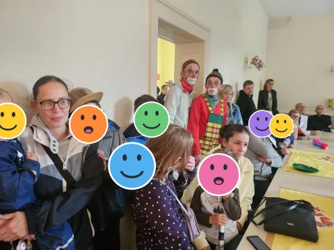Kalle Clowns mit Familien beim Weltkindertag; die Kinderköpfe sind mit Smileys verdeckt