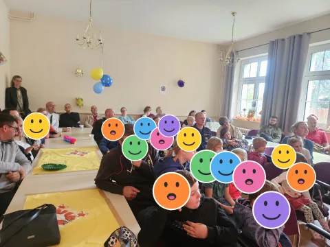 Viele Gäste verfolgen das Programm zum Weltkindertag; die Kinderköpfe sind mit Smileys verdeckt