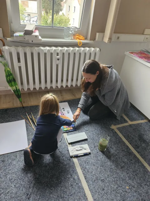 Kind beim Malen im Bürger- und Vereinshaus von hinten