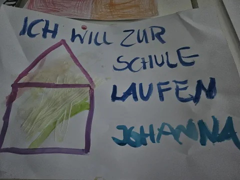 Kinderzeichnung mit der Aufschrift Ich will zur Schule laufen